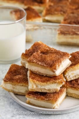 Cream Cheese Squares on a plate with dish full in the back