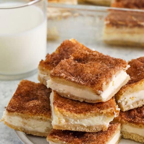 Cream Cheese Squares on a plate with dish full in the back