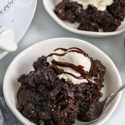 bowls of Crockpot Lava Cake with ice cream and crock pot in the back