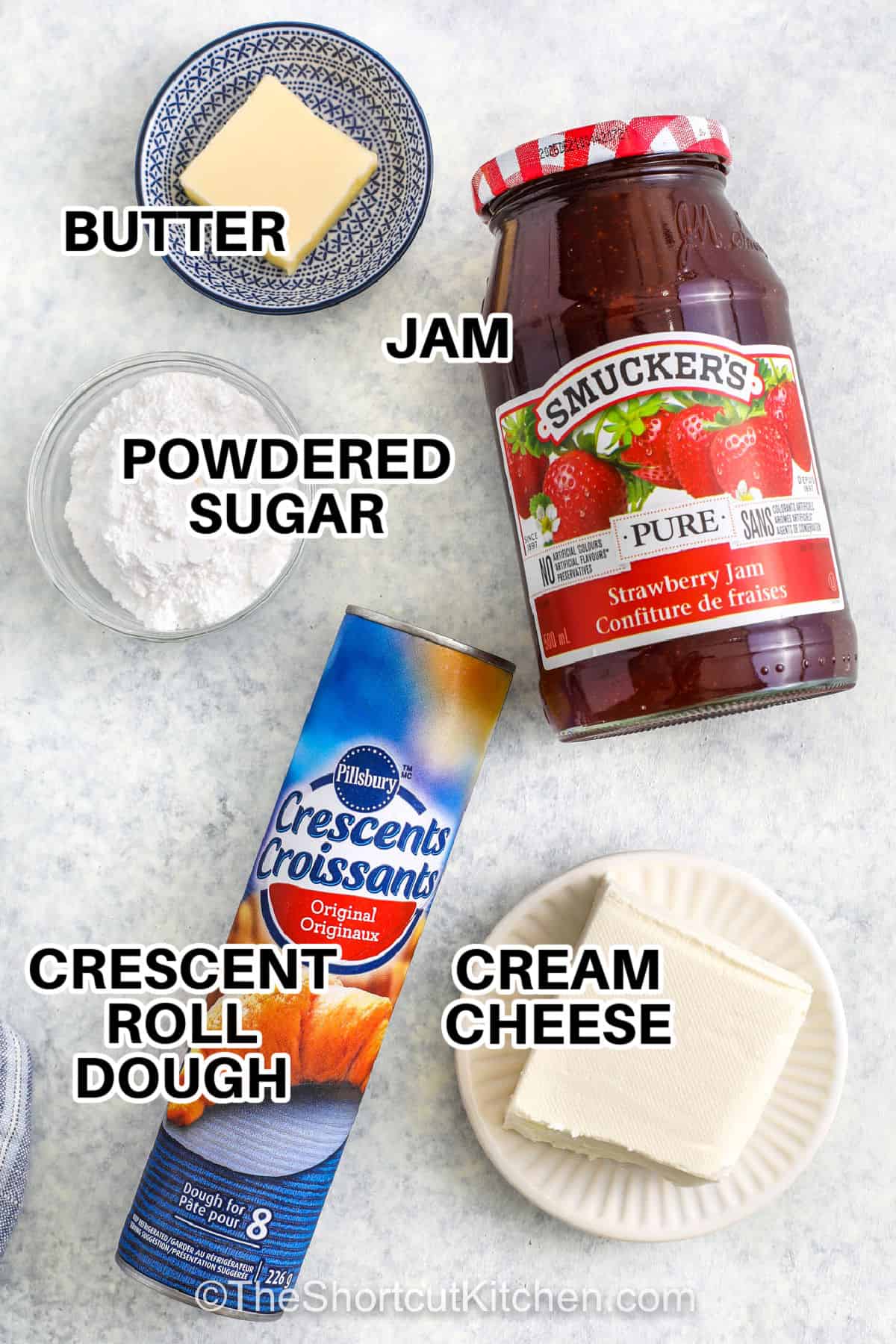 This cream cheese crescent rolls recipe with fruit filling is an easy method to make a sweet and creamy breakfast pastry. Crescent roll dough is rolled up around a filling of cream cheese and fruit jam or pie filling, then brushed with butter and baked until golden. Any fruit flavor can be used. Try cherry, blueberry, apple, or strawberry. Sprinkle with cinnamon, powdered sugar, or chocolate syrup and make it a dessert. This homemade danish will be a family favorite. #theshortcutkitchen cream cheese , crescent roll dough , jam , powdered sugar , butter with labels to make Cream Cheese Crescent Rolls