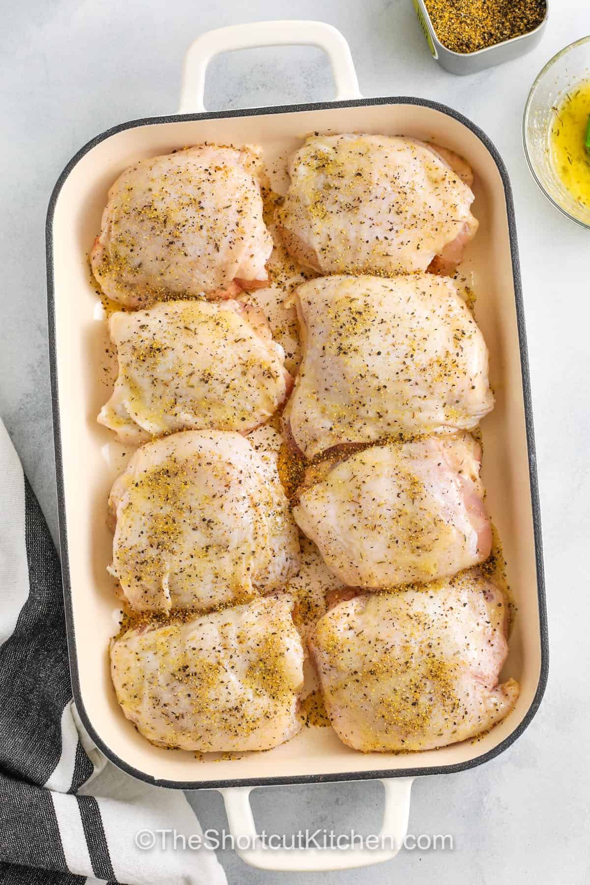 seasoned chicken in a dish to make Lemon Pepper Chicken Thighs