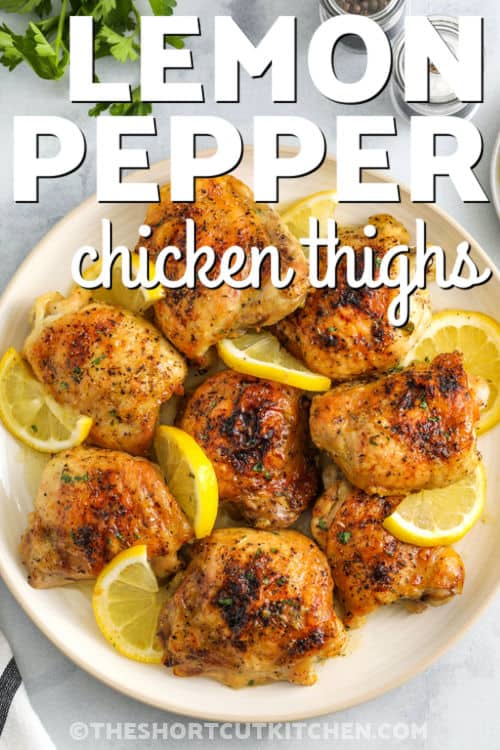 Lemon Pepper Chicken Thighs on a plate with lemon slices and a title