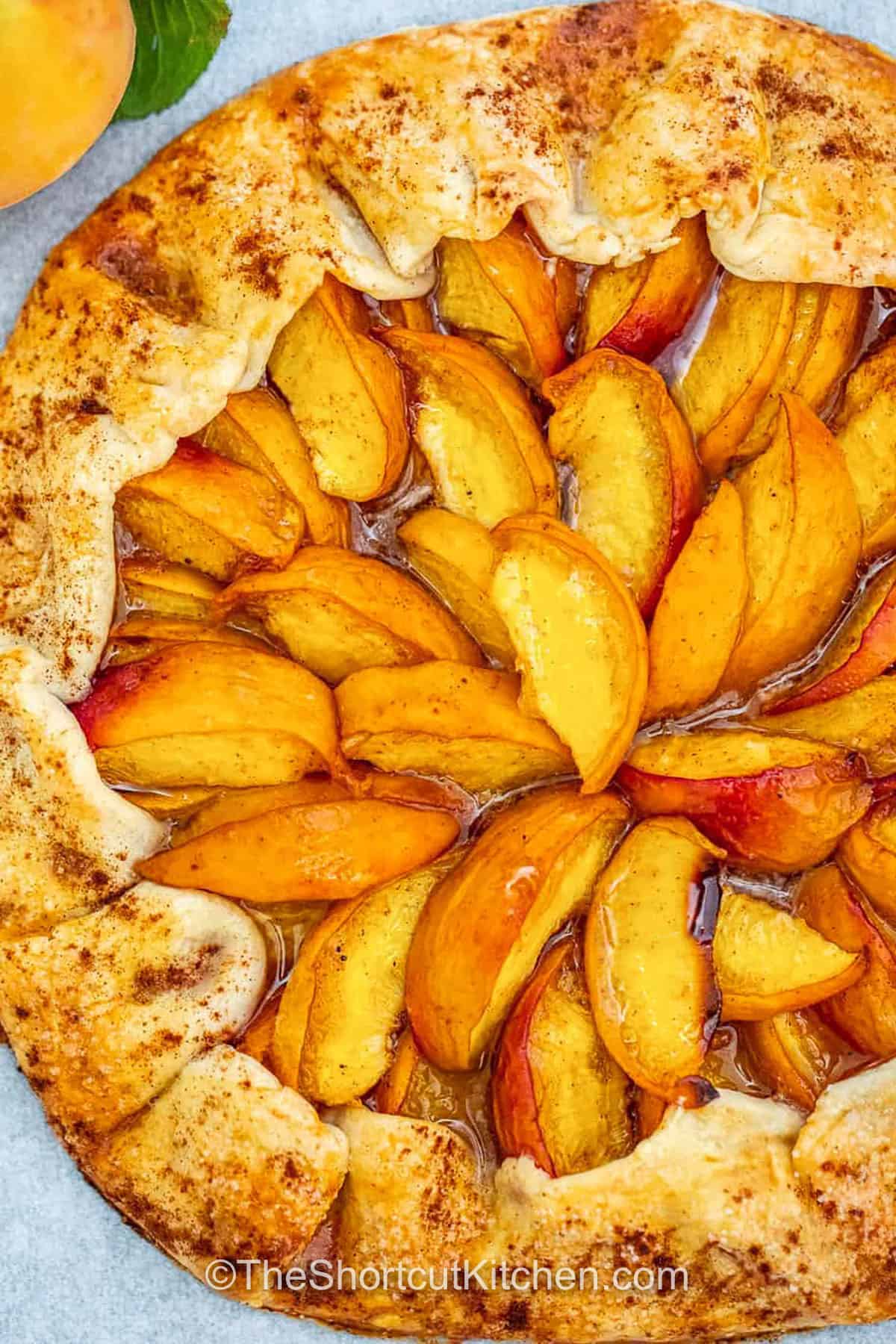This peach galette recipe is the kind of easy, homemade dessert that makes summer special. It’s got that rustic, open-face look with buttery edges and a golden crust that cradles juicy, fresh peaches in every bite. The warm spices give it that comforting flavor you love in a tart, and it’s just so simple to make. Add a scoop of vanilla or a dollop of cream, and it’s ready for guests or a quiet night in. #theshortcutkitchen baked Peach Galette Recipe
