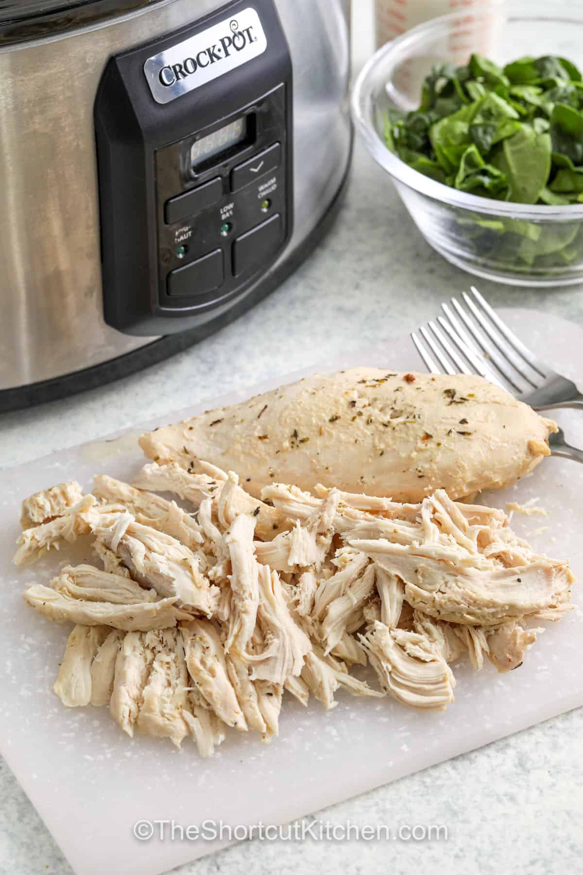 Tuscan chicken soup is an easy recipe that brings rustic Italian flavors to your table. Slow-cooked chicken, creamy broth, and white beans make it hearty, while spinach and sundried tomatoes add freshness and tang. Finished with garlic and Parmesan, it’s the kind of meal that feels special yet simple to prepare. #theshortcutkitchen shredded chicken to make Crockpot Tuscan Chicken Soup
