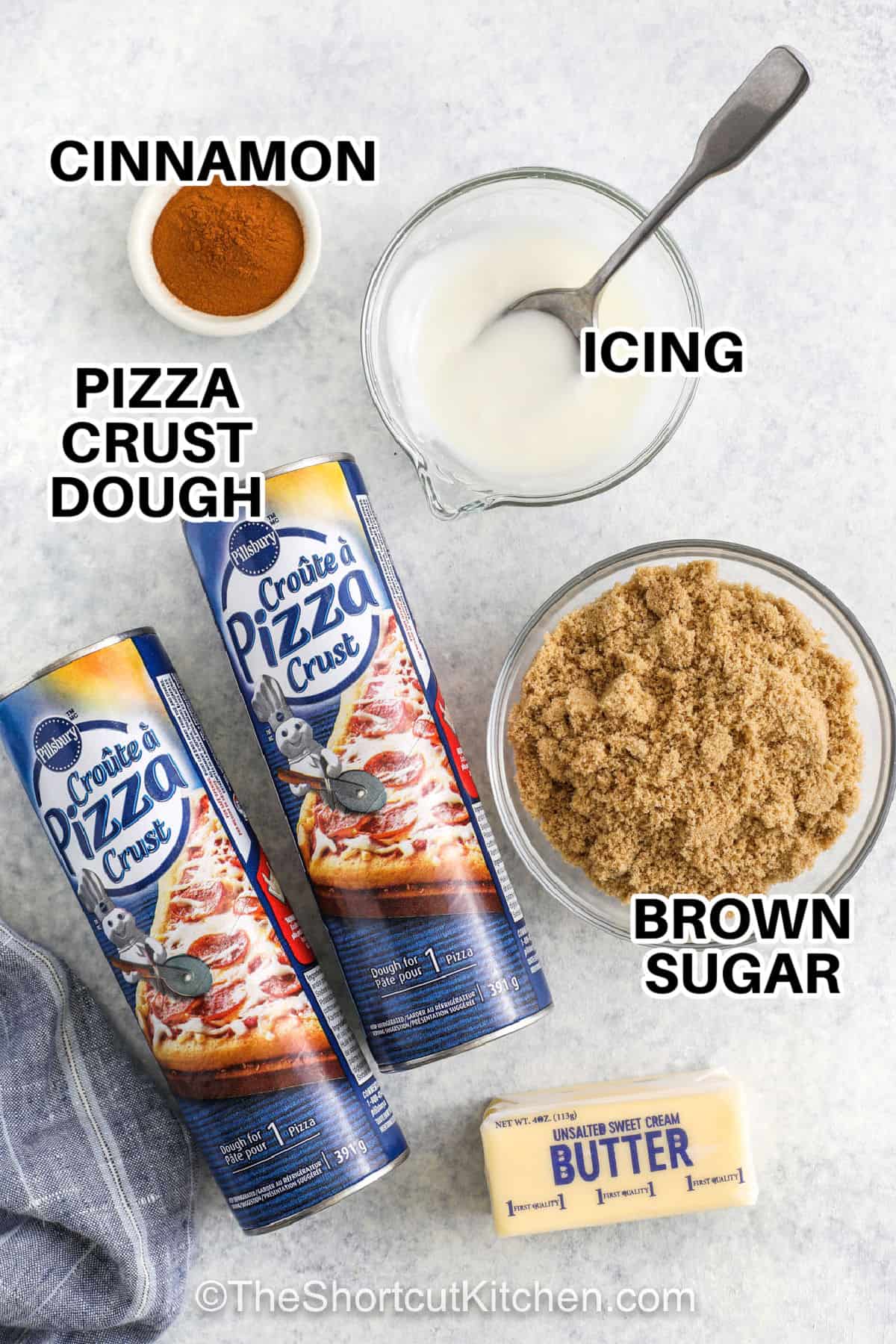 Cinnamon pull apart bread is the best thing since monkey bread! Refrigerated pizza dough is crosshatch sliced and stacked with a buttery cinnamon and brown sugar filling. After baking to a toasty golden brown and drizzling with a sweet vanilla glaze, each layer pulls apart into a sticky delight. This family-friendly treat is best enjoyed with a crowd! #theshortcutkitchen cinnamon , icing , brown sugar , butter , pizza crust dough with labels to make Cinnamon Pull Apart Bread