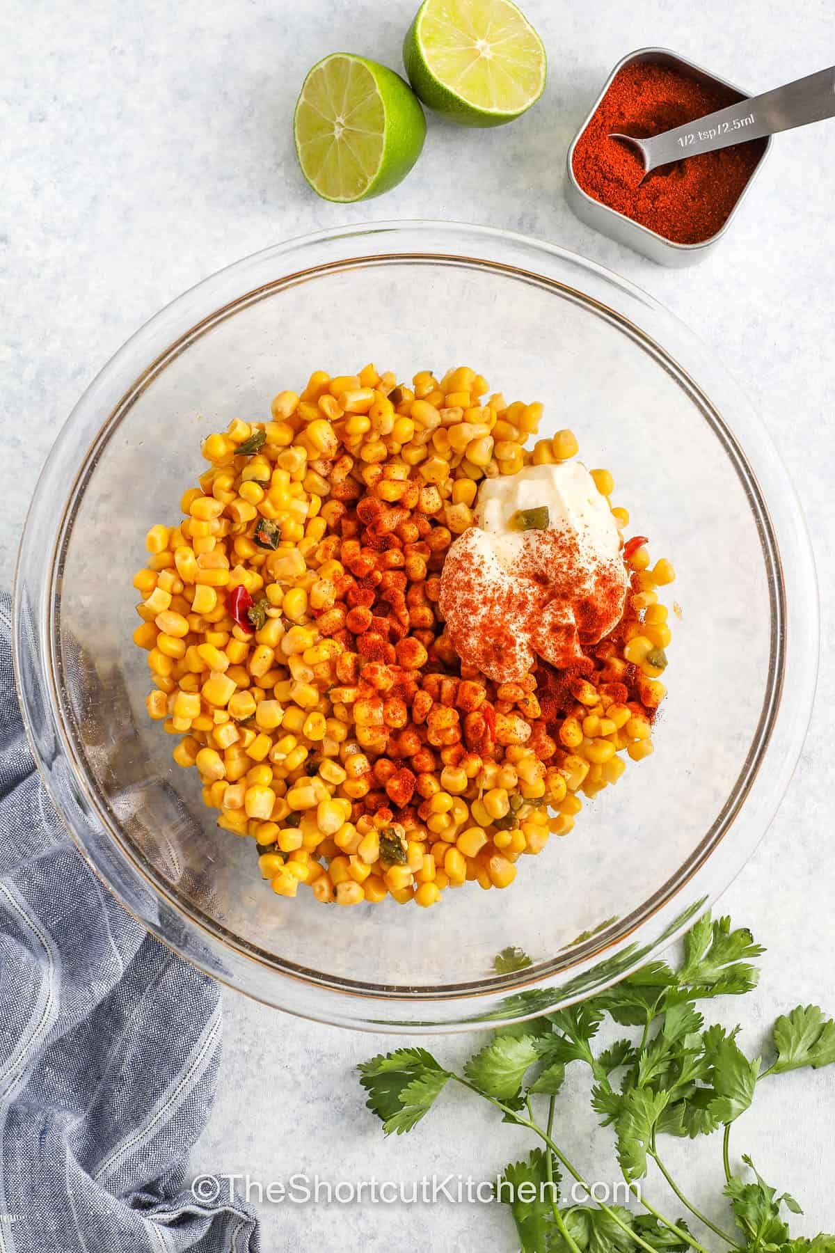 adding seasonings and mayo to corn to make Mexican Corn Salad With Canned Corn