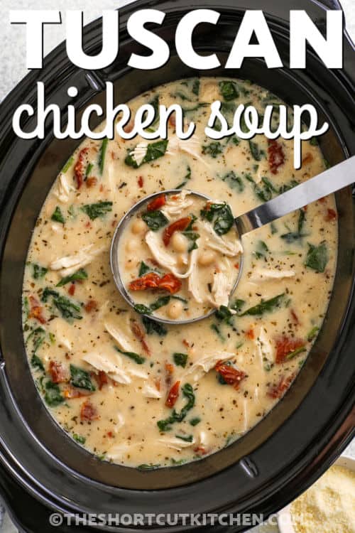 Tuscan chicken soup is a creamy, comforting blend of tender shredded chicken, white beans, and earthy spinach, all simmered together in a rich slow cooker broth. Sun-dried tomatoes and garlic bring deep flavor while Parmesan adds a savory finish. This delicious and easy slow cooker recipe is full of wholesome ingredients that come together for a bowl the whole family will love. #theshortcutkitchen hot and cozy Crockpot Tuscan Chicken Soup with writing