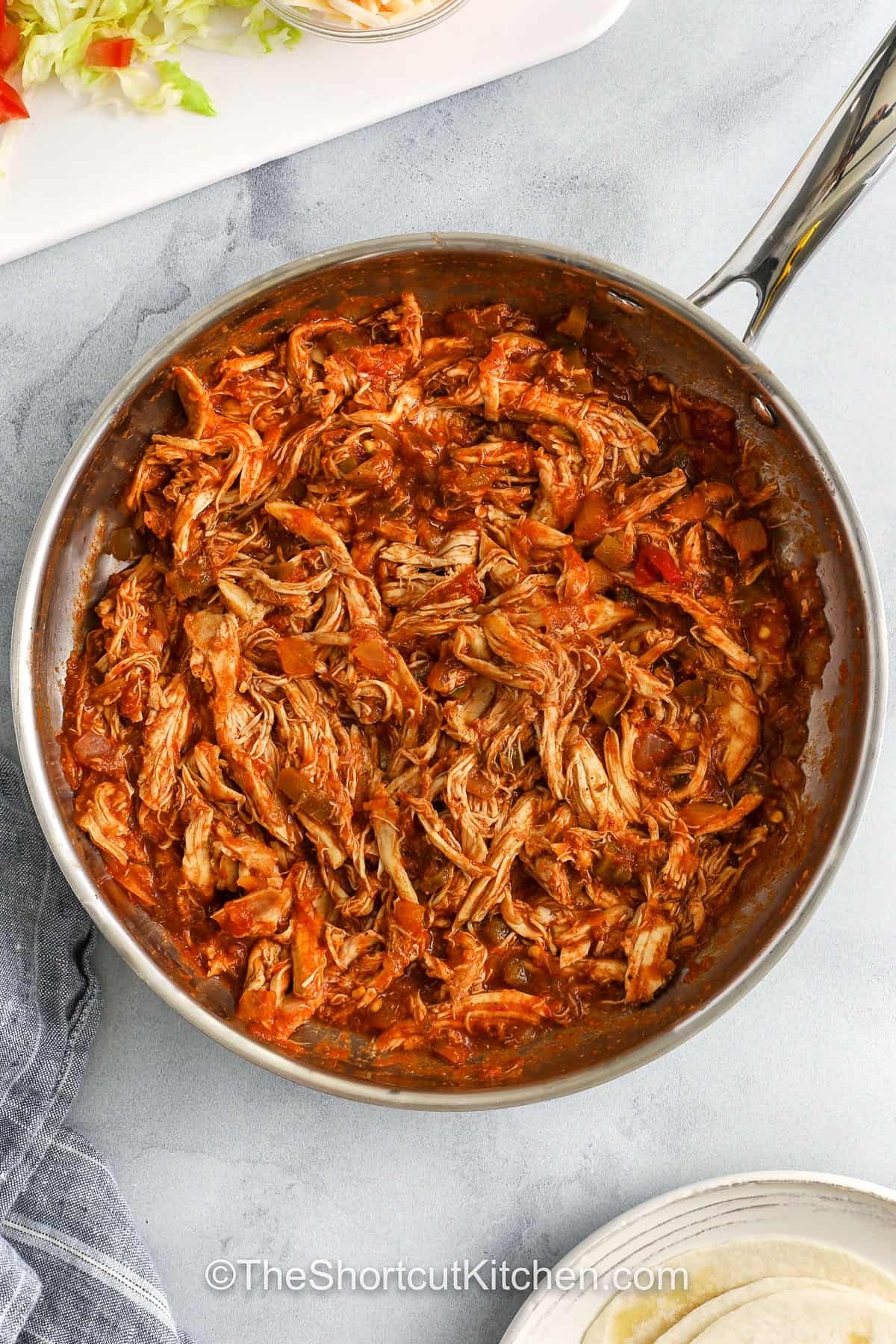 cooked chicken in a pan to make Rotisserie Chicken Tacos
