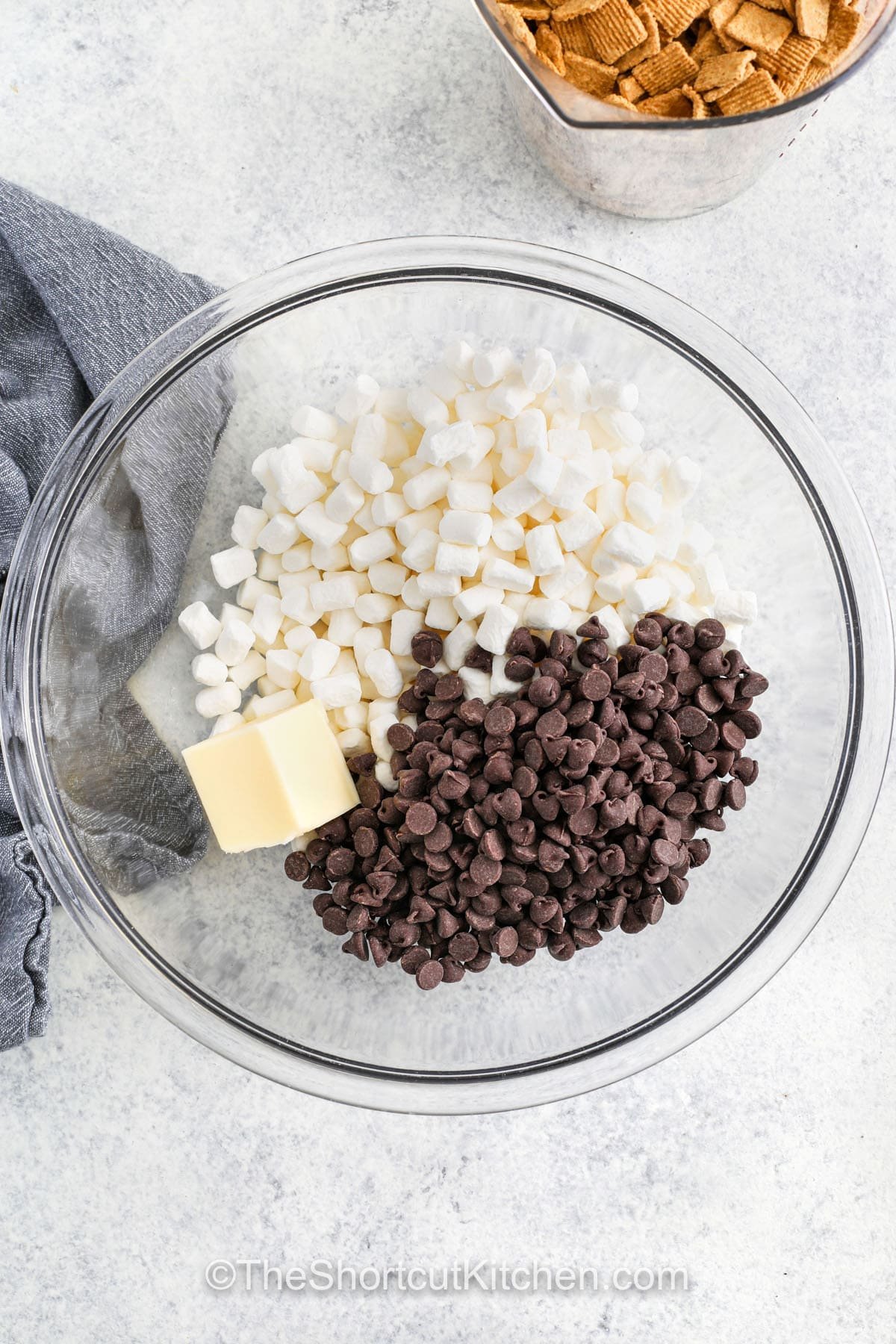 marshmallows, butter and chocolate chips in a microwave safe mixing bowl to make s'mores bars