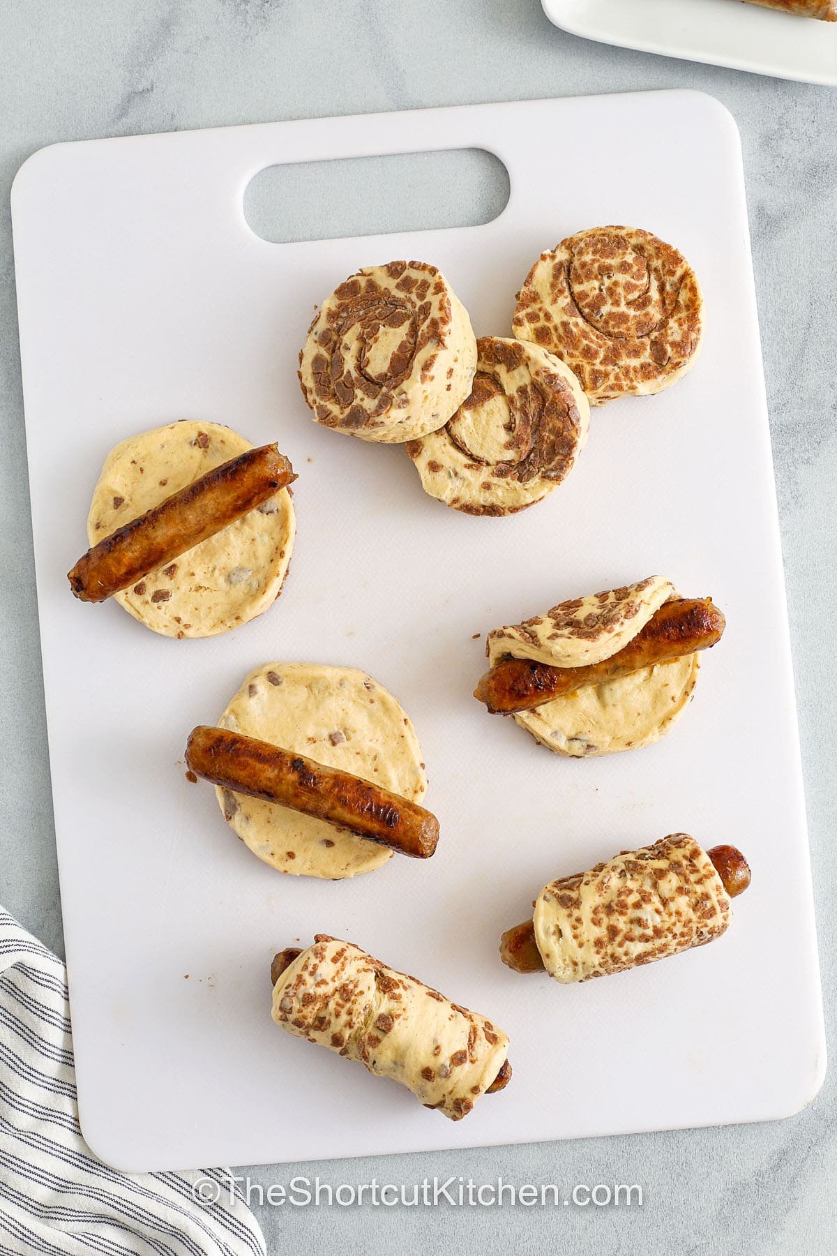 wrapping sausages in cinnamon rolls to make Breakfast Pigs in a Blanket