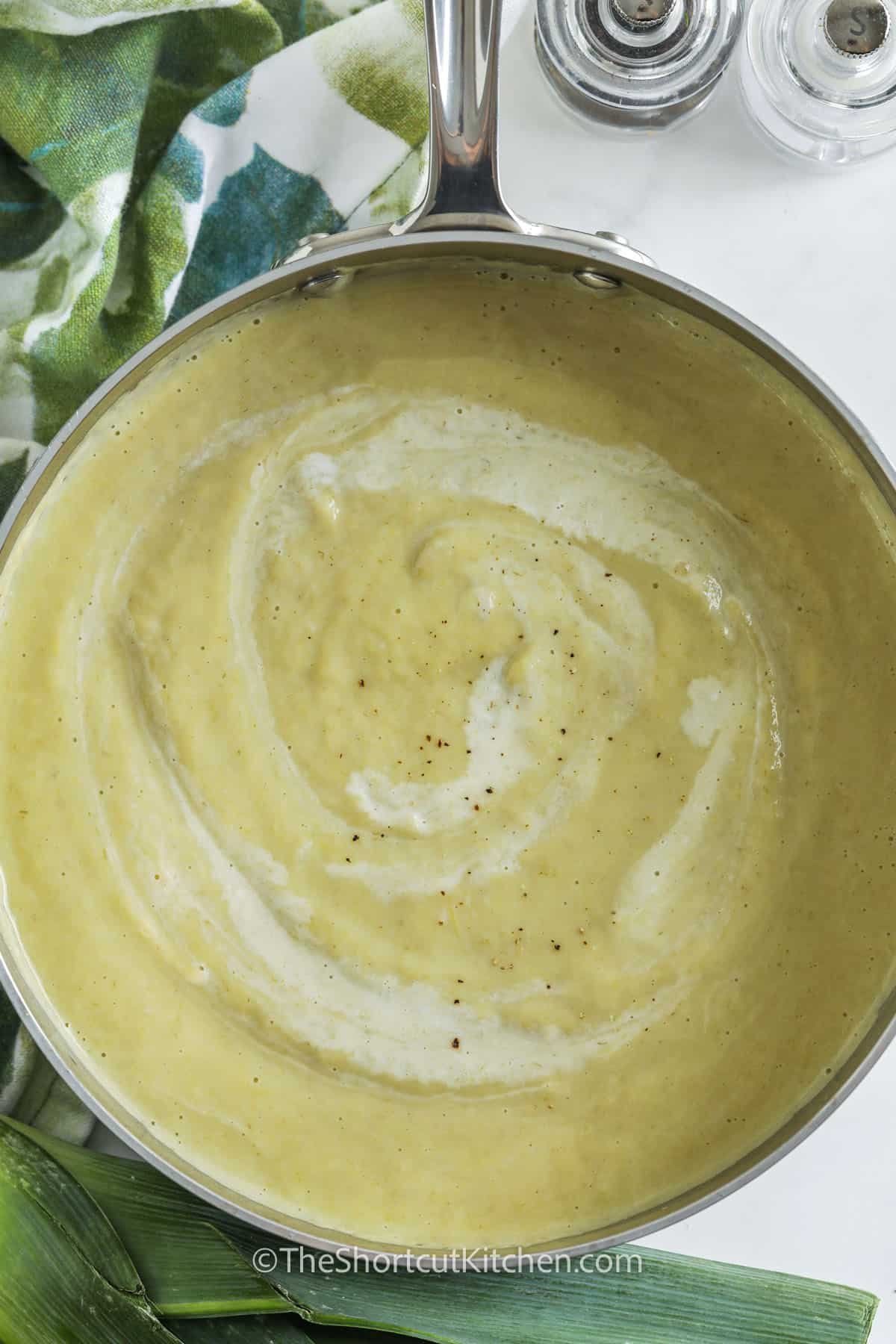 Cauliflower leek soup is a creamy, comforting classic that’s both nourishing and satisfying. Made with fresh vegetables and rich cream, it's a one-pot wonder that’s easy to prepare and full of flavor. The soup gets its luxurious texture from a quick blend and a splash of cream at the end. It's perfect for batch cooking and tastes even better the next day. Serve with crusty bread! #theshortcutkitchen pot full of Cauliflower Leek Soup