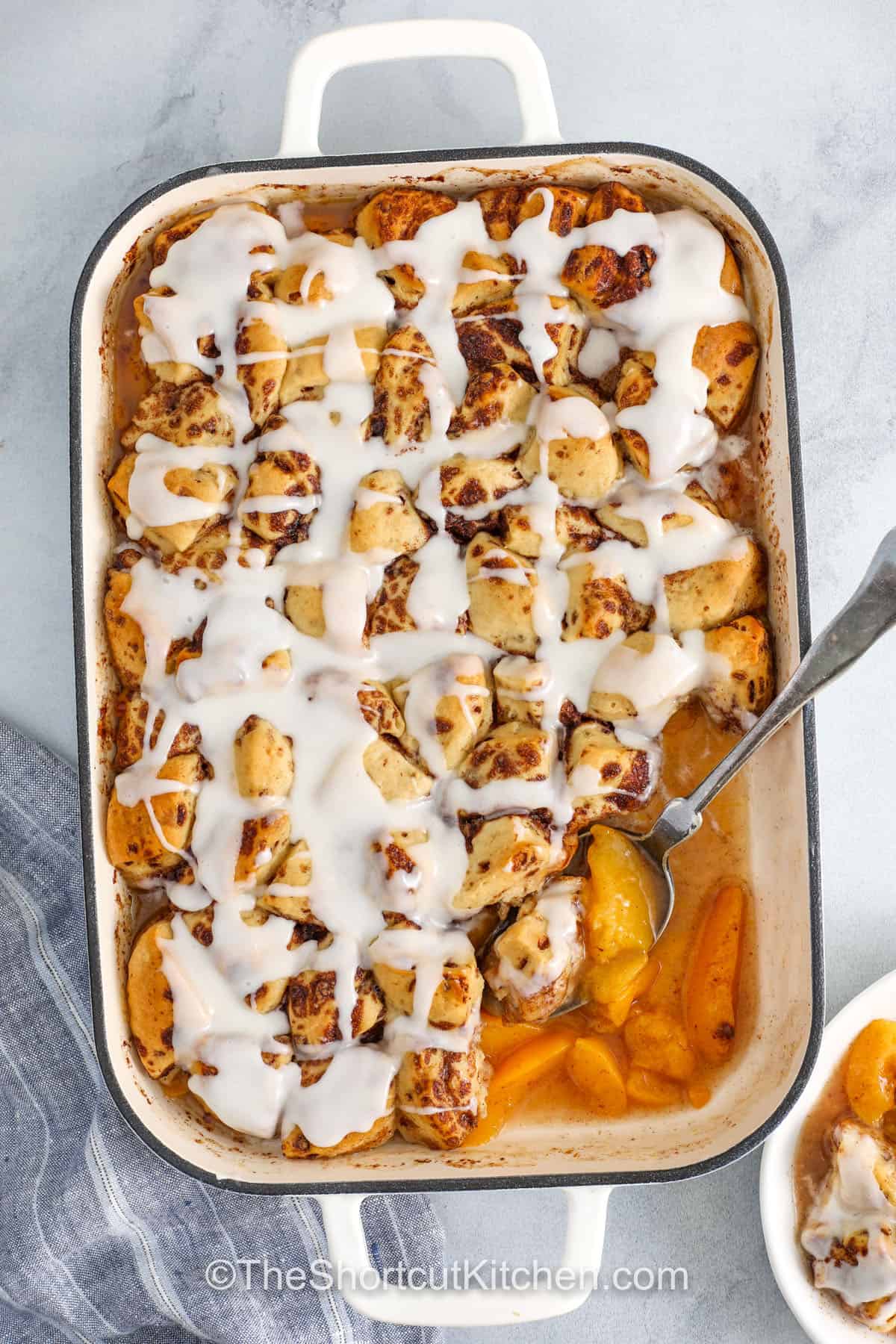 casserole dish full of Cinnamon Roll Peach Cobbler