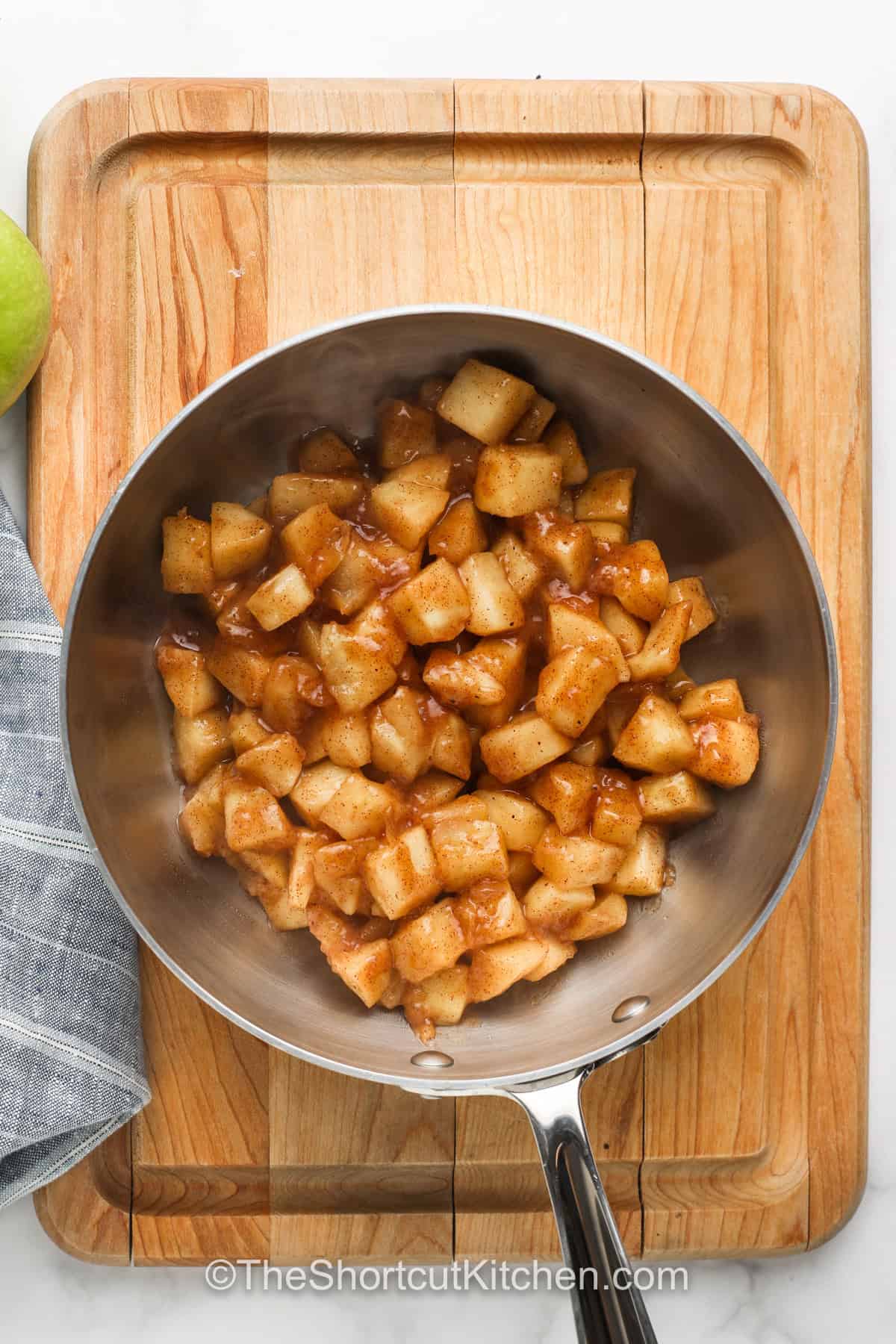 You’ll love this easy apple pie filling recipe for making homemade desserts and pastries. It’s so easy to make from basic scratch ingredients and fresh apples. Prep the apples by peeling and coring, and cook on the stovetop with sugar, some warming spices, and a little butter for creamy richness. It only takes a few minutes to make this simple apple pie filling. You can refrigerate or freeze it for all your future baking needs. #theshortcutkitchen Easy Apple Pie Filling in the pan