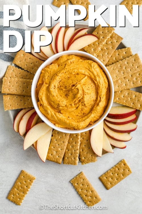 Pumpkin dip in a serving bowl with crackers and apples with a title