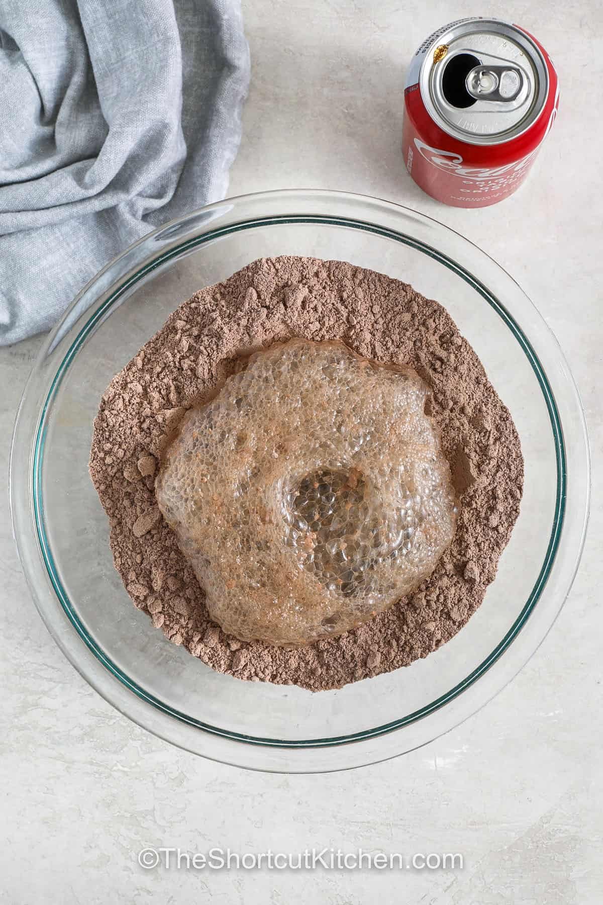 Cake mix soda cake is the kind of easy dessert that never fails to impress. With just a box of cake mix and a can of pop, you’ll have a fluffy cake that’s light and full of flavor. It’s perfect for birthdays, potlucks, or any sweet craving. You can top it with fruit, whipped cream, or frosting for a simple but special finish. This recipe is made for sharing and always turns out great. #theshortcutkitchen adding soda to cake mix to make Cake Mix Soda Cake