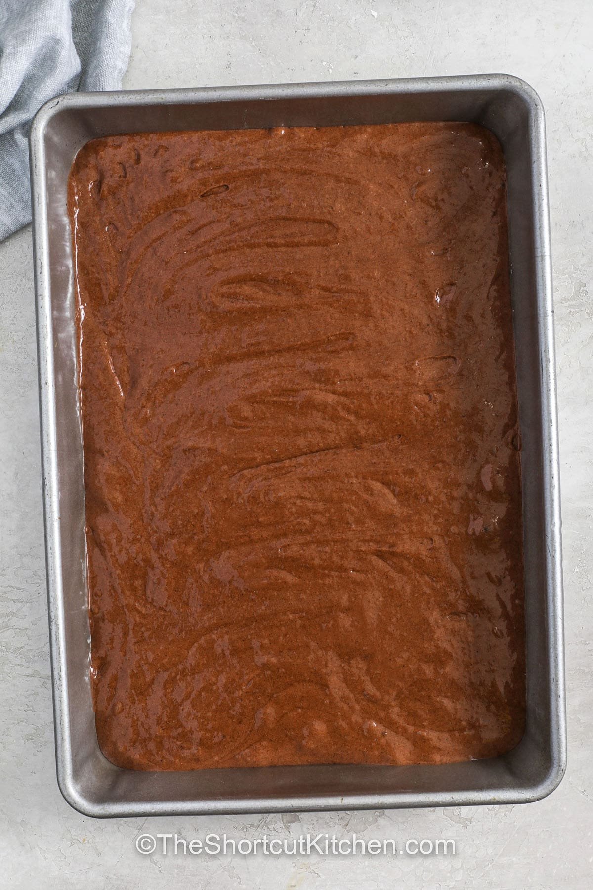 Cake mix soda cake is an easy and quick dessert anyone can make. It starts with a box of mix and a can of soda that bake into a soft, moist treat. This two-ingredient recipe makes baking simple and fun, and the results are always delicious. Top it with frosting, fruit, or whipped topping for a special touch. It’s perfect for a party or an everyday treat your family will love. #theshortcutkitchen Cake Mix Soda Cake in a dish before cooking