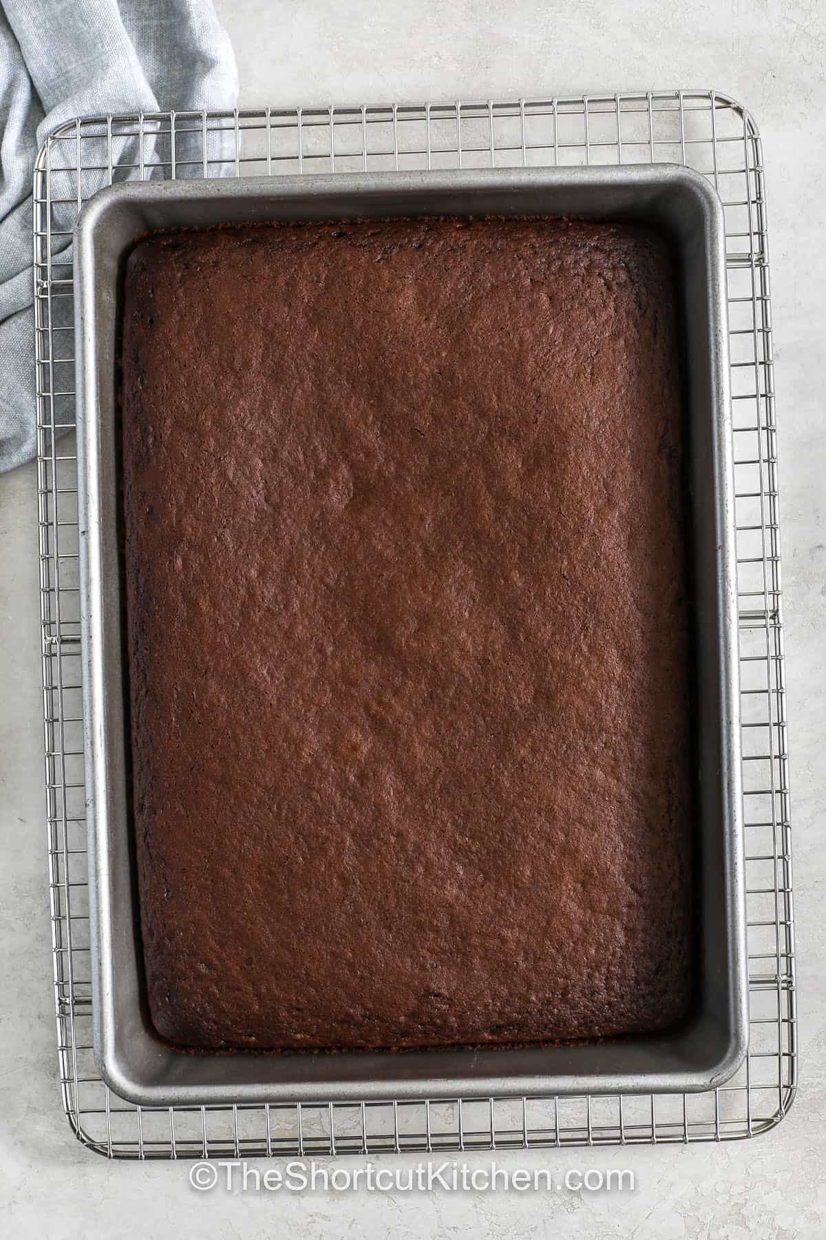 Cake mix soda cake makes baking fun and simple with only two ingredients. All you need is a box of mix and a can of soda to create a soft, moist dessert everyone will love. It’s perfect for birthdays, parties, or anytime you crave something sweet. This easy recipe can be topped with whipped cream or fruit for a bright finish. You’ll love how light and delicious it turns out. #theshortcutkitchen baked Cake Mix Soda Cake in the pan