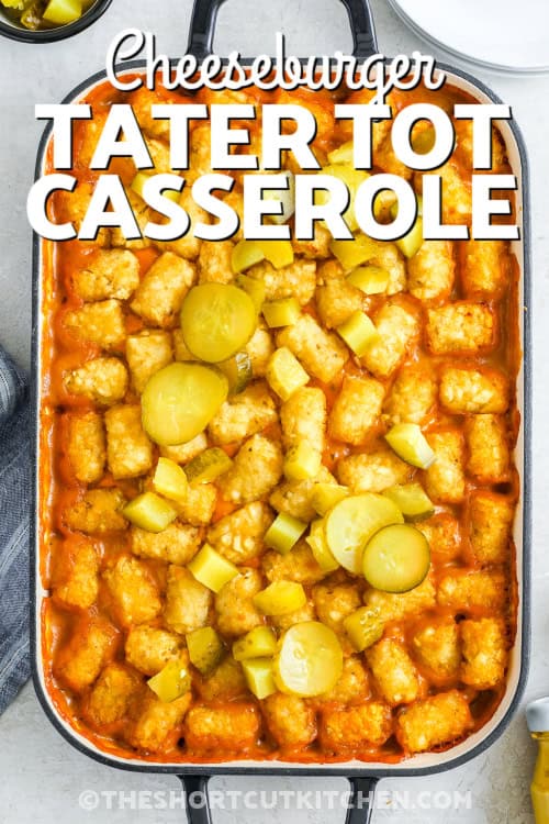 This cheeseburger tater tot casserole combines all your favorite burger flavors in a one-pan, easy-to-make meal, with seasoned ground beef, diced onions, creamy cheddar sauce, shredded cheddar, and a crispy tater tot topping. Bake it until golden and bubbling, then add pickles if you like, and serve a dish that’s fun, satisfying, and full of classic cheeseburger comfort in every cheesy, crunchy bite. #theshortcutkitchen A cheeseburger tater tot casserole topped with sliced pickles and a title