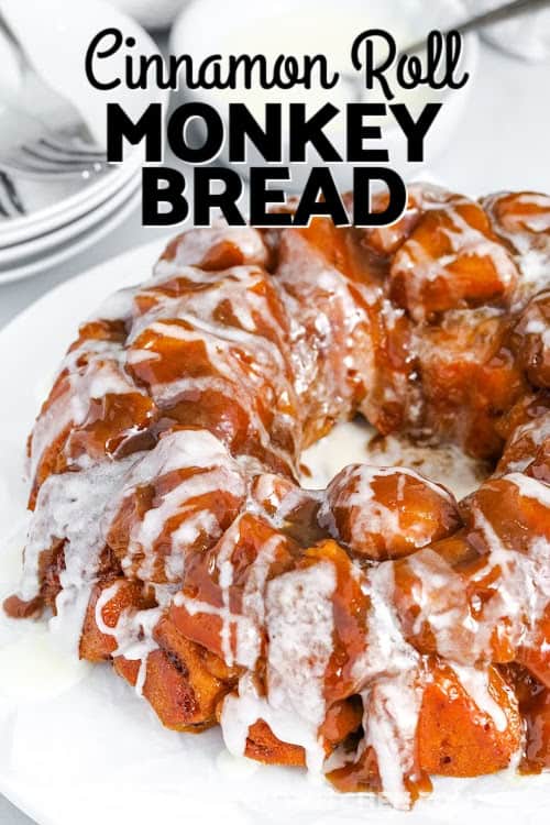 Cinnamon roll monkey bread is a deliciously sticky, gooey treat that’s shockingly easy to make. Start with canned cinnamon rolls, toss with butter, brown sugar, and cream, then bake to perfection in a bundt pan. The final touch is a sweet glazed icing drizzle. Great for brunch, a quick dessert, or your next holiday gathering. This shortcut recipe is one of the best things you can pull off without breaking a sweat! #theshortcutkitchen Cinnamon Roll Monkey Bread on a serving plate with a title