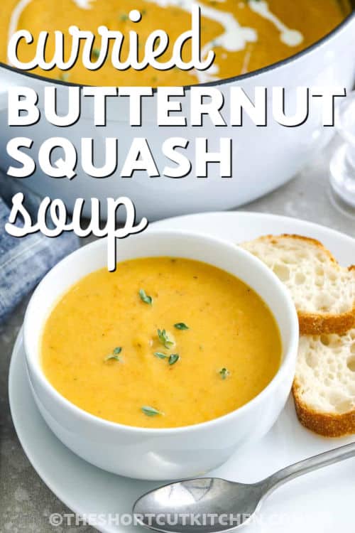 This curried butternut squash soup is creamy, sweet, and perfectly spiced for fall. Silky coconut milk or rich cream blend with roasted squash and curry for a smooth, velvety finish. The flavors are both savory and cozy, warming you from the inside out. It’s an easy, simple recipe that turns everyday ingredients into a comforting harvest classic. #theshortcutkitchen bowl of Curried Butternut Squash Soup with pot full in the back and a title