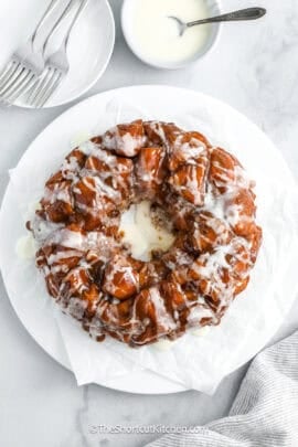 Cinnamon Roll Monkey Bread on a serving plate drizzled with icing