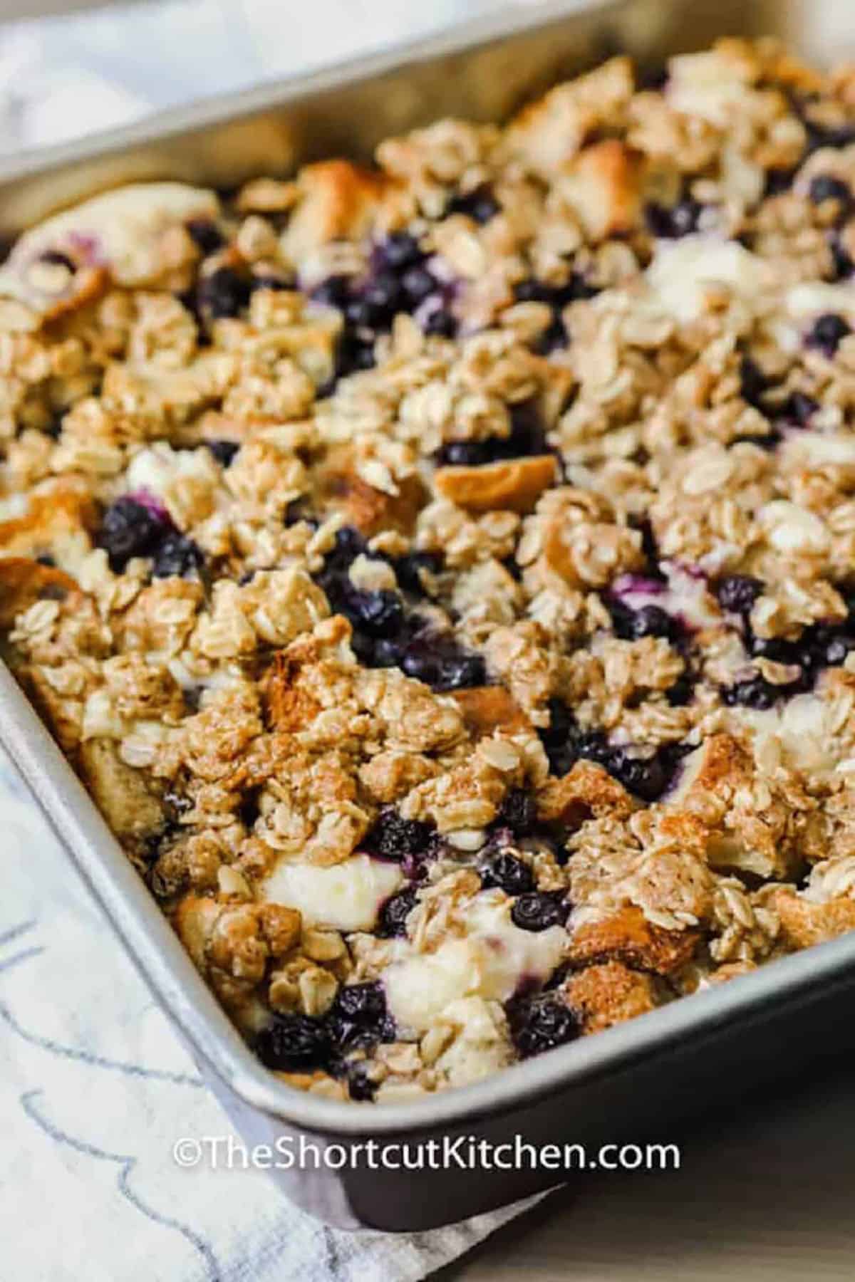 Blueberry French toast bake brings together everything you love about a warm and comforting breakfast casserole by blending bread, soft cream cheese custard, and bursts of blueberries into every moist and fluffy bite. This overnight baked creation fits perfectly into easy morning routines, offering a sweet and friendly option for family meals or holiday brunch gatherings. Its inviting aroma fills the kitchen and makes every weekend feel special. #theshortcutkitchen Blueberry French Toast Bake in a pan
