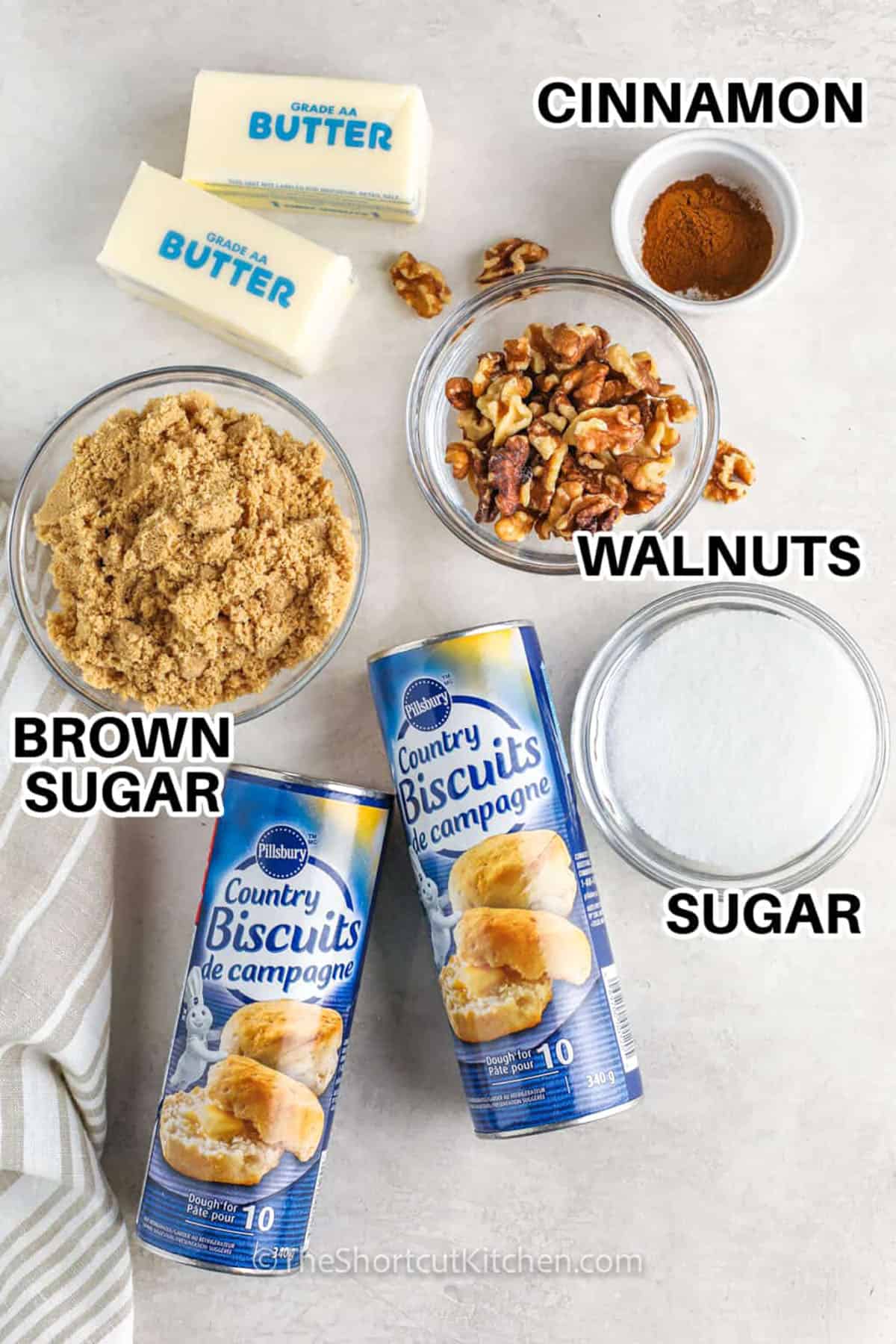 Easy monkey bread is a sweet and gooey treat that is great for breakfast or brunch, and every bite has a warm cinnamon and buttery caramel flavor that makes it a family favorite. The sticky pull apart pieces come from simple ingredients that bake into a no fuss quick bread everyone can enjoy together. Serve it warm on a holiday morning or share it at any gathering for a quick and cozy treat. #theshortcutkitchen cinnamon , brown sugar , walnuts , sugar , biscuits dough with labels to make Easy Monkey Bread