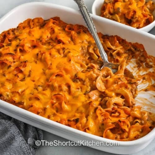 hearty and cheesy Beef Noodle Casserole in casserole dish and bowls