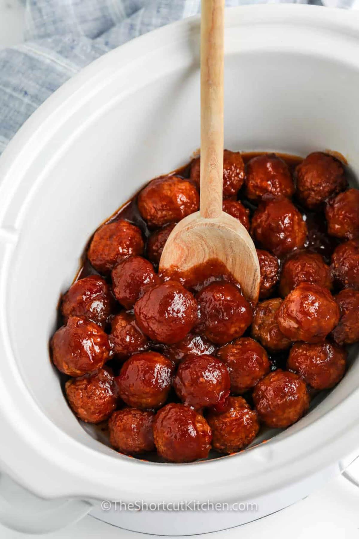 Crockpot grape jelly meatballs make entertaining simple by using just three ingredients that transform into a flavorful dish as they heat low and slow. The grape jelly adds sweetness while chili sauce brings zest, creating a nostalgic glaze that sticks to each meatball. This easy slow-cooker method yields a warm, irresistible appetizer perfect for game days and family gatherings. #theshortcutkitchen juicy Crockpot Grape Jelly Meatballs in the pot