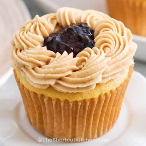 horizontal peanut butter and jelly cupcakes, with one on a tiny cupcake stand