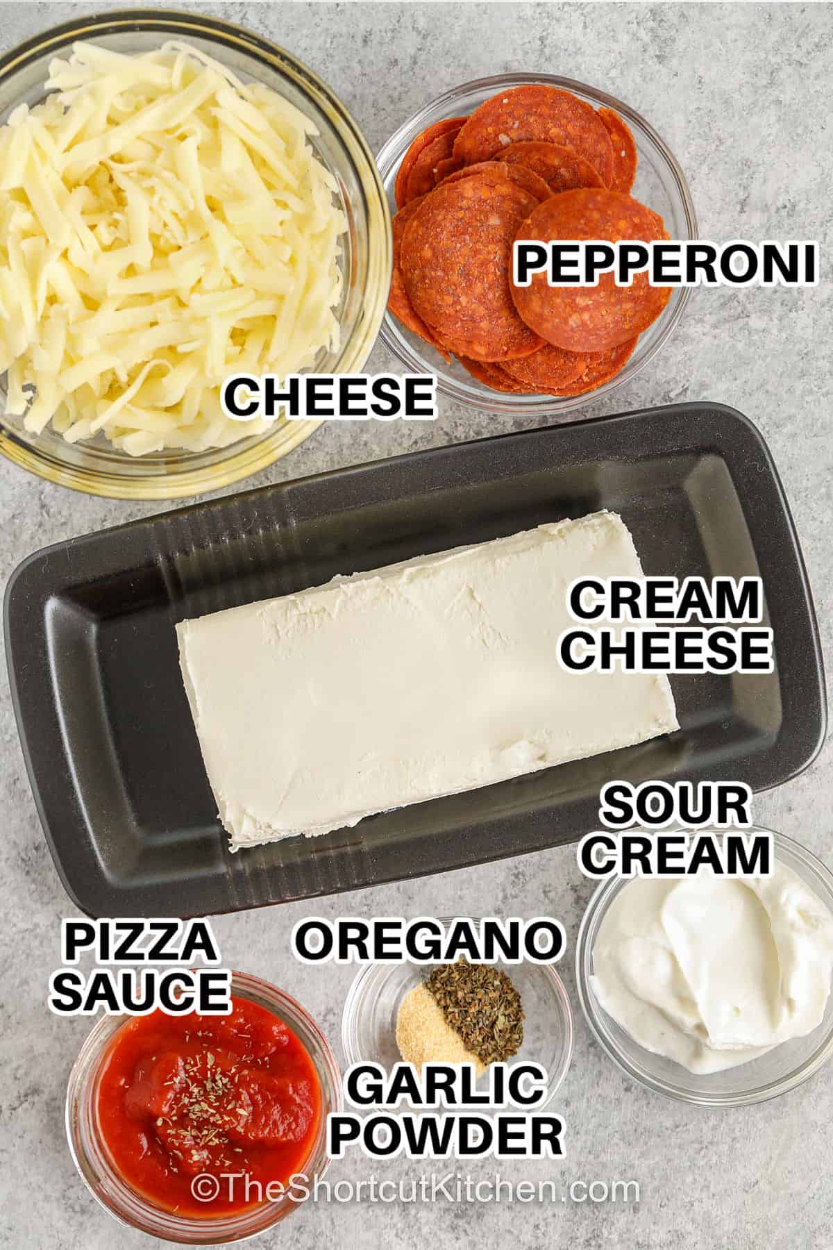 This pizza dip recipe has everything you love in one hot and creamy bite. It’s packed with melted cheese, zesty sauce, garlic, and pepperoni for that perfect pizza flavor. It’s simple to make and always a crowd pleaser. Serve it with crusty bread, crackers, or veggies for a snack that’s just as good as a slice of pizza but even easier to share. #theshortcutkitchen cheese , pepperoni , cream cheese , sour cream , oregano , garlic powder , pizza sauce with labels to make Pizza Dip Recipe
