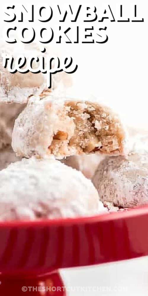 snowball cookies on a cake platter with writing