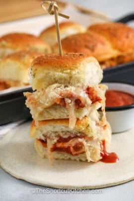 chicken parm sliders on a plate with a bowl of marinara
