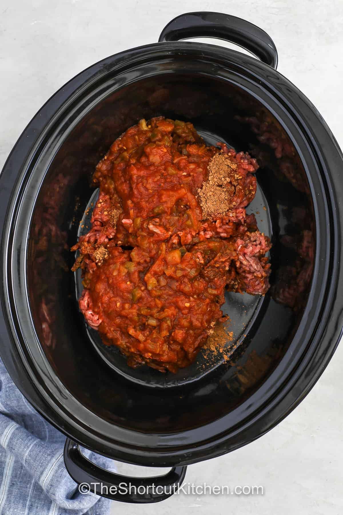 Make this Crockpot taco meat using ground beef, taco seasoning packets, and salsa for a saucy, scoopable filling. It is packed with classic taco flavor. The meat cooks low and slow for tender results every time. Ideal for taco bars, parties, busy weeknights, or freezer meals. With just three pantry-friendly ingredients, this recipe delivers fast prep and big flavor. #theshortcutkitchen adding ingredients to pot to make Crockpot Taco Meat