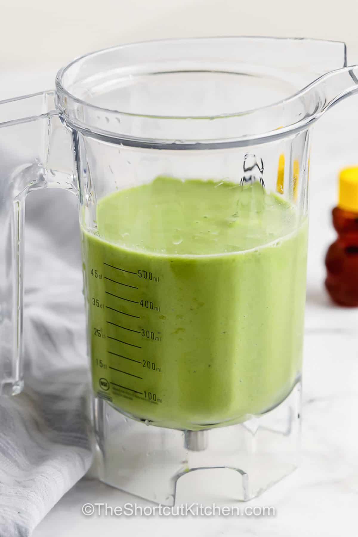 A delicious Green Smoothie Recipe made with spinach, yogurt, banana, and pineapple is sure to get the whole family moving in the morning. Frozen fruit makes it cold, creamy, and quick to make anytime. Try this sweet smoothie recipe made with dairy or plant-based milk, or add in some extras like hemp, chia, or even nuts. A quick breakfast that’s always a hit! #theshortcutkitchen Green Smoothie Recipe in a blender