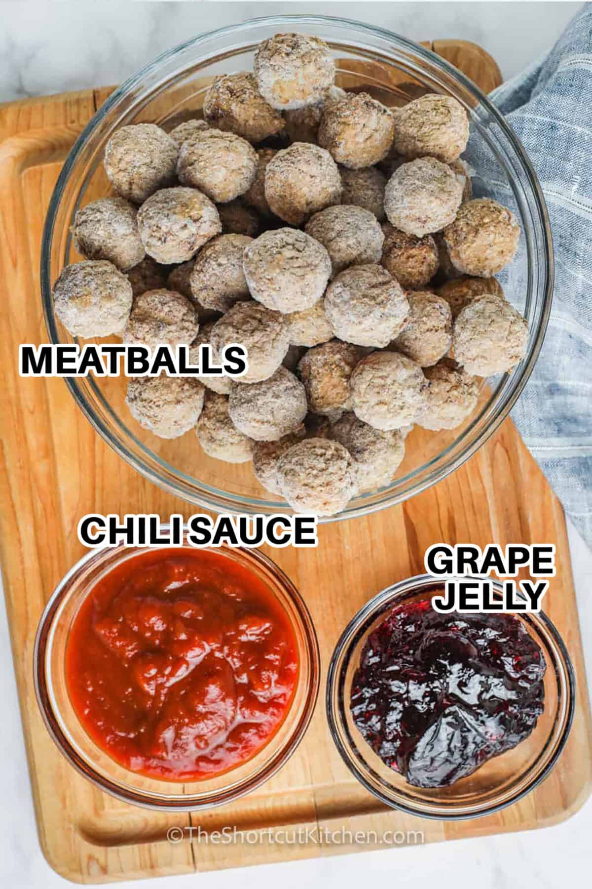 Crockpot grape jelly meatballs deliver big flavor with minimal effort, relying on the slow cooker to blend the sweetness of grape jelly with the bold kick of chili sauce. As the mixture warms, the sauce becomes silky and rich, coating each meatball evenly. They’re a dependable favorite for potlucks, parties, or busy nights when you want something delicious without fuss. #theshortcutkitchen Chili sauce, grape jelly, and meatballs on a wooden board to make crockpot grape jelly meatballs.