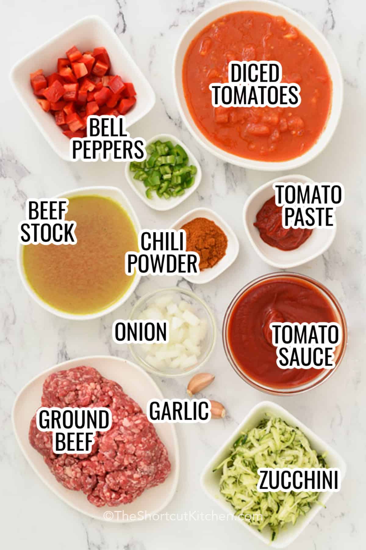 Make easy chili with ground beef, kidney beans, diced tomatoes, tomato sauce, and cozy chili spices. This easy beef chili is a simple one-pot stovetop dinner that simmers into a thick, hearty bowl. Perfect for busy weeknights, game day, and leftovers. Serve with cheese, sour cream, onions, chips, or cornbread, and freeze extra portions for fast lunches. #theshortcutkitchen ingredients to make easy chili, including peppers, diced tomatoes, beef stock, chili powder, tomato paste, onion, tomato sauce, garlic, ground beef, and zucchini