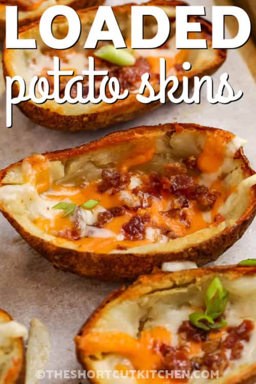 These Loaded Potato Skins bake up crispy without any frying. Brush the scooped skins with melted butter and salt, bake cut-side down to crisp them up, flip, then fill with cheddar blend and bacon bits. Bake again just until the cheese melts, then top with fresh green onions. A cozy, crowd-pleasing appetizer that is fun to prep and perfect to serve on a snack board or a party appetizer tray. #theshortcutkitchen cheesy baked Loaded Potato Skins with a title
