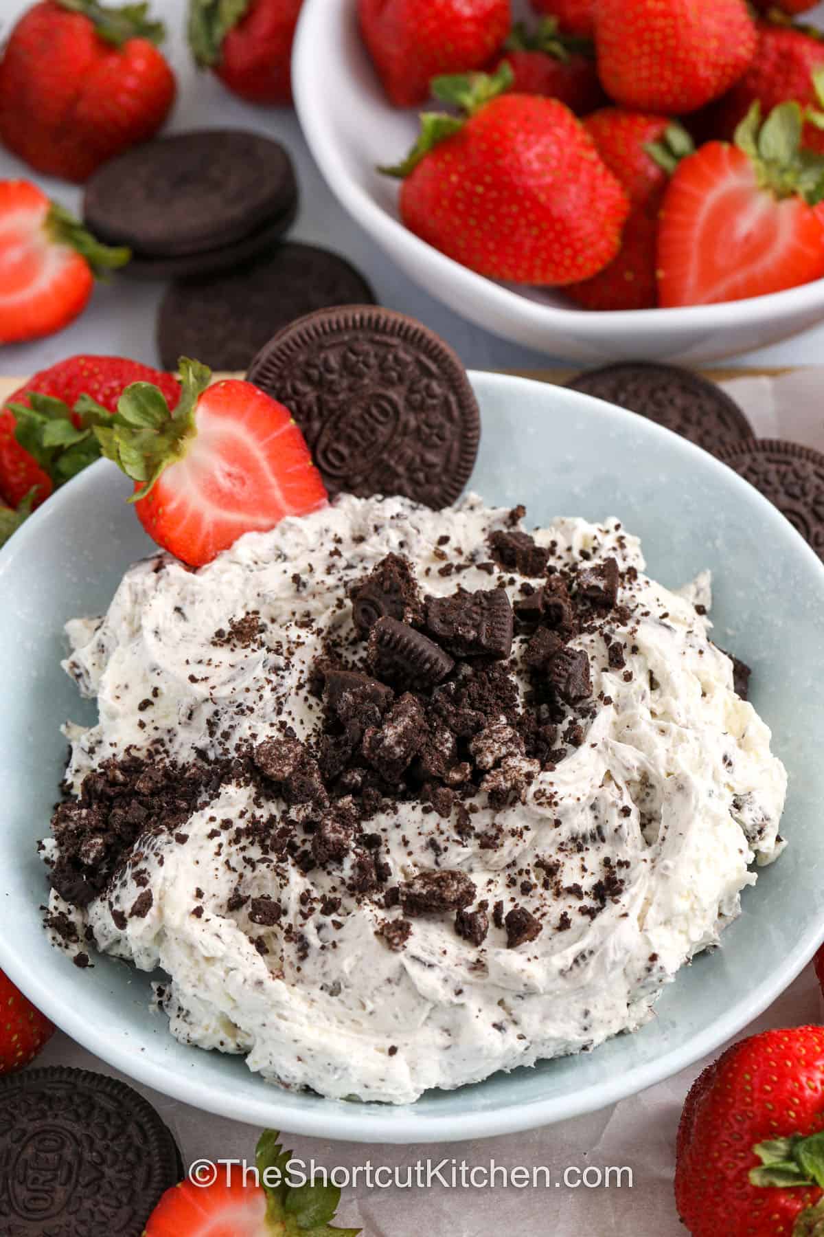 This Oreo dip recipe is a sweet and fluffy cookies and cream dip. It’s made with cream cheese, whipped topping, powdered sugar, and plenty of crushed Oreo cookies. It’s an easy no bake dessert that comes together in minutes. It is the perfect Oreo dessert dip for parties, holidays, or last-minute snacks. Serve this creamy Oreo Dip with fruit, pretzels, vanilla wafers, or even more Oreos. #theshortcutkitchen close up of Oreo Dip in bowl