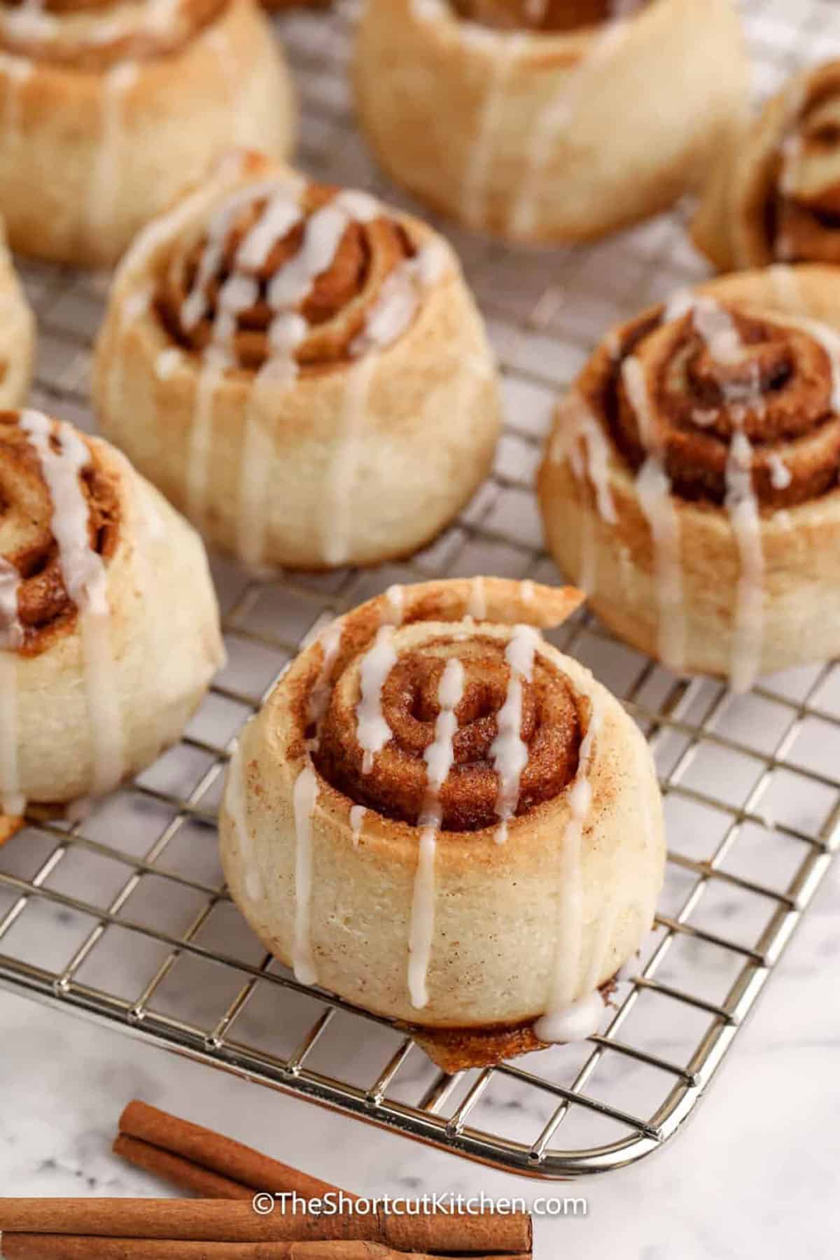 These Pizza Dough Cinnamon Rolls are a shortcut recipe to make using refrigerated pizza dough plus butter, cinnamon, and brown sugar. Just four ingredients, then slice, bake, and drizzle with a simple glaze for a cozy breakfast or dessert. Pillsbury pizza dough cinnamon rolls bake up soft in a 9×9 pan with minimal effort. #theshortcutkitchen Pizza Dough Cinnamon Rolls with icing