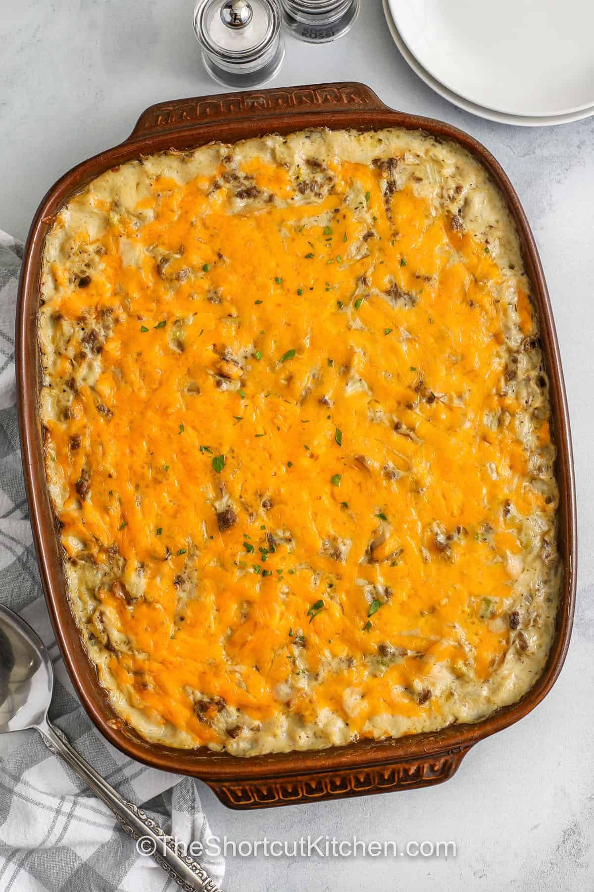 If you love creamy casseroles, make this hamburger rice casserole. It’s a ground beef and rice casserole where the rice cooks right in the sauce made from condensed soups and milk, so the oven does most of the work. Add optional canned mushrooms for extra savory flavor, then top with cheddar cheese for a cheesy hamburger casserole finish. Great for leftovers and meal prep. #theshortcutkitchen cheesy baked Hamburger Rice Casserole