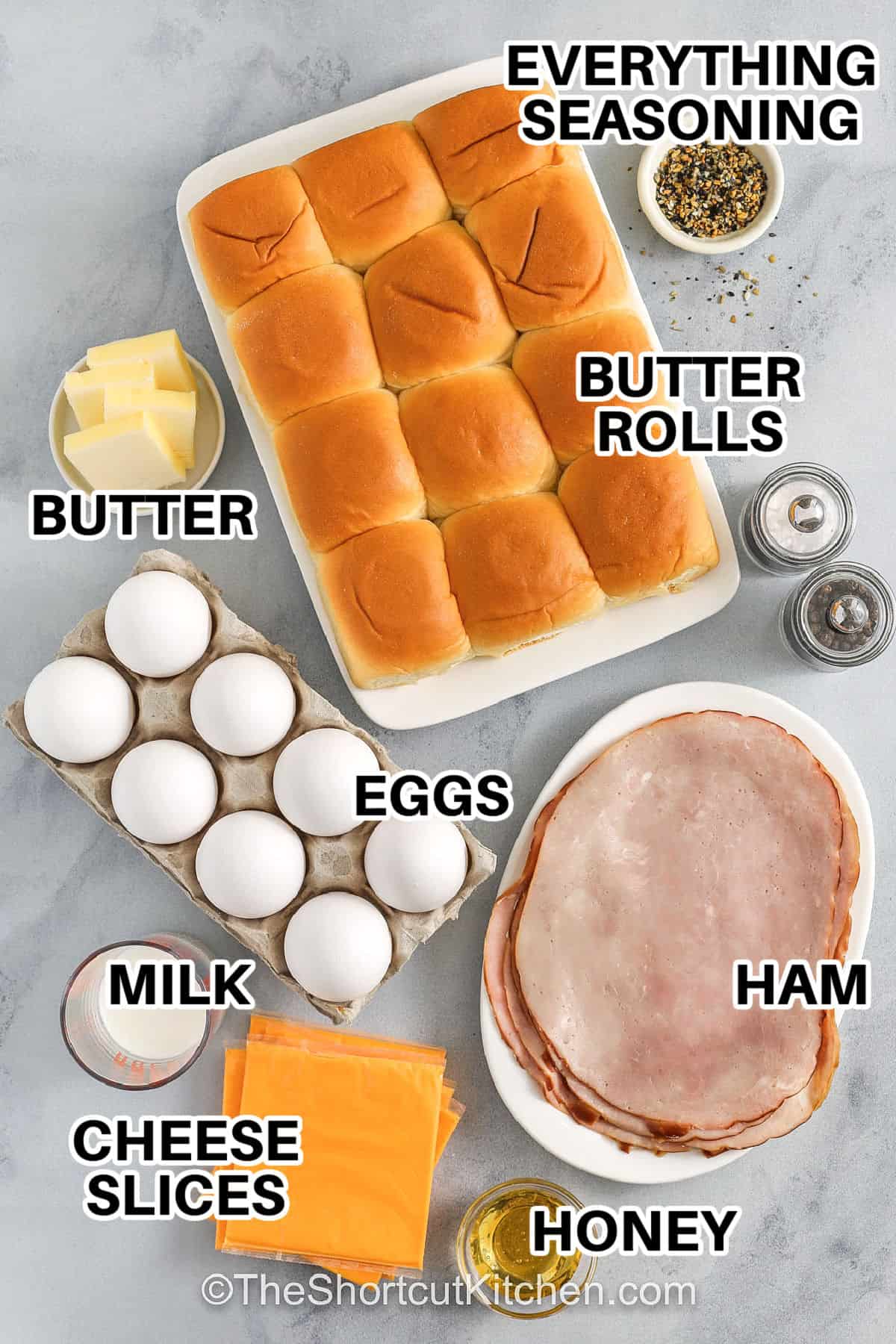 Breakfast sliders are the ultimate make-ahead win for busy mornings, brunch spreads, or feeding a crowd without stress. Soft Hawaiian rolls are layered with fluffy scrambled eggs, savory ham, and melty cheese, then brushed with buttery honey and everything bagel seasoning for a sweet and savory finish. Baked until golden and warm, these sliders pull apart easily and taste amazing fresh from the oven. Simple ingredients, big flavor, and total comfort food vibes. #theshortcutkitchen everything seasoning , butter rolls , butter , eggs , milk , cheese slices , honey , ham , salt and pepper with labels to make Breakfast Sliders