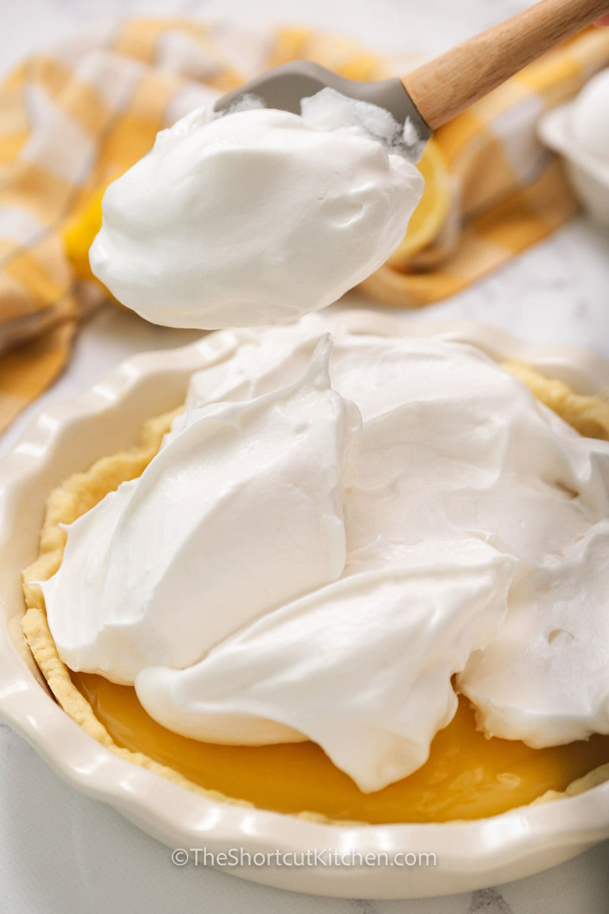 Make an easy lemon meringue pie with pie filling using canned lemon pie filling and a quick meringue topping. A baked pie crust keeps it crisp, and stiff, glossy peaks give you that classic toasted finish. This simple method is perfect for spring gatherings, holidays, or when you want a bright lemon dessert with minimal effort and maximum wow. #theshortcutkitchen adding meringue to Lemon Meringue Pie