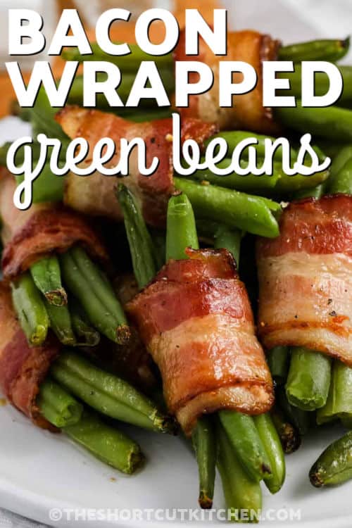 Make bacon wrapped green beans the easy way with frozen green beans, no trimming or blanching needed. Wrap 5–6 beans per bundle, drizzle with maple syrup, and oven bake until the bacon is crisp and the beans are tender. These bacon wrapped green bean bundles are perfect for entertaining and can be assembled ahead of time for stress-free cooking. #theshortcutkitchen plate of Bacon Wrapped Green Beans with a title