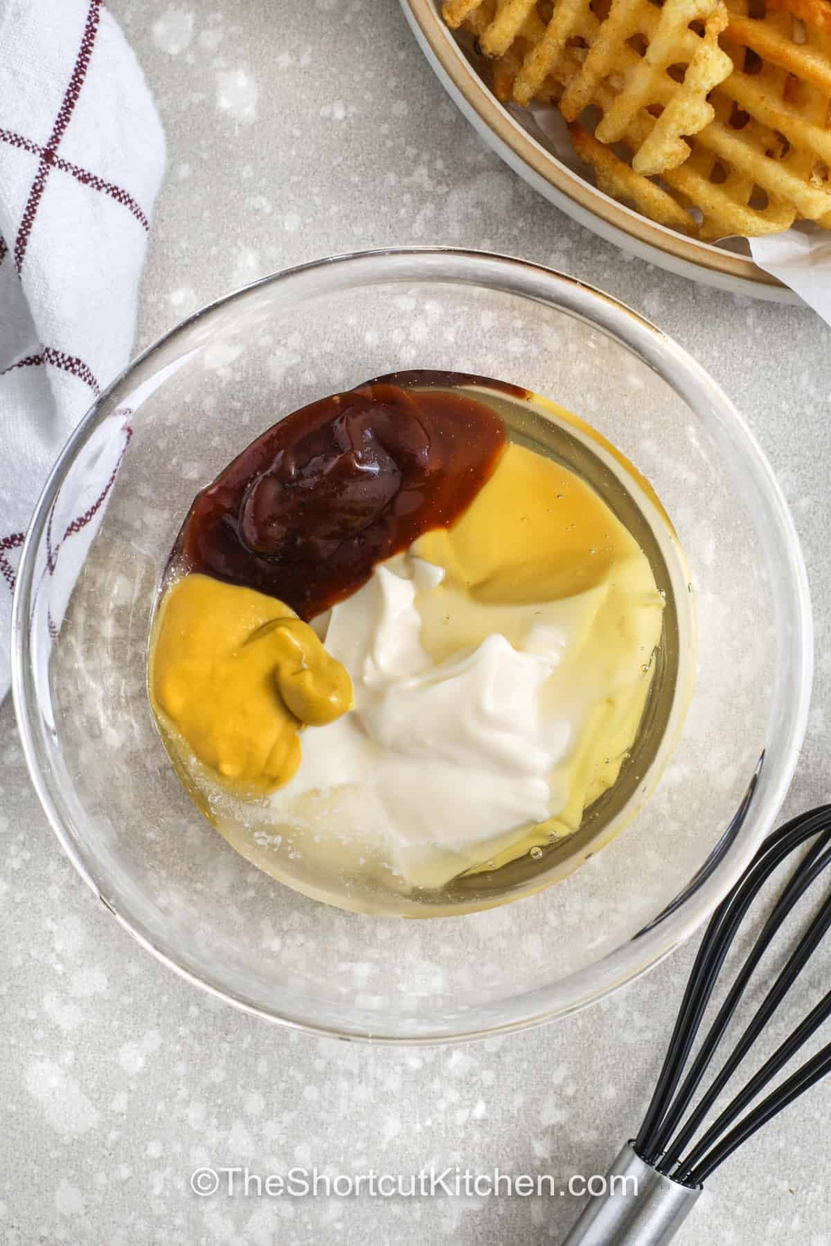 Chick-Fil-A sauce recipe cravings are easy to fix with this smooth and flavorful homemade version that uses pantry staples. This copycat Chick-Fil-A sauce recipe blends mayo, honey, mustard, and BBQ sauce into a creamy dip that pairs perfectly with chicken nuggets, fries, or sandwiches. It has that sweet and smoky taste you love and mixes up easily for any meal. Keep it chilled and ready to add a little extra flavor to lunches, snacks, or dinner plates. #theshortcutkitchen ingredients in a bowl, unmixed, for chick-fil-a sauce recipe