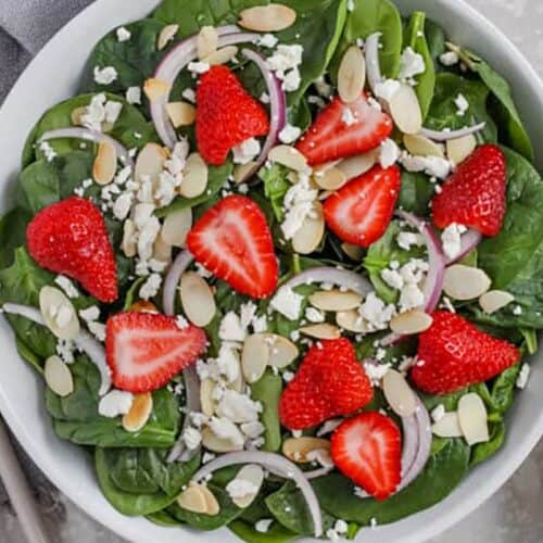A serving dish of prepared Strawberry and spinach salad
