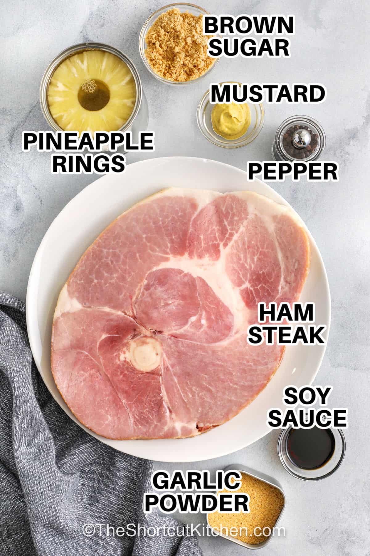 This ham steak recipe combines pineapple and a brown sugar glaze to create a classic, delicious dinner. The ham steak is baked in the oven with a sauce of mustard, soy sauce, garlic, and black pepper for a rich, savory flavor. Pineapple rings add a touch of sweetness that complements the ham perfectly. This meal is a great option for a simple family dinner or a smaller holiday gathering. Serve it with roasted vegetables, mashed potatoes, or rice for a satisfying dinner. #theshortcutkitchen pineapple rings , brown sugar , mustard , pepper , soy sauce , garlic powder , ham steak with labels to make Ham Steak