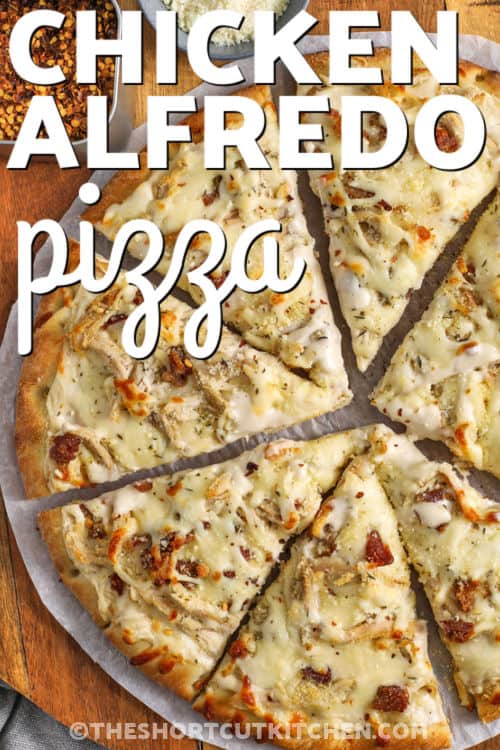 Alfredo pizza is a creamy, cheesy twist on pizza night that everyone enjoys. A crisp pre-baked crust is layered with rich Alfredo sauce, juicy rotisserie chicken, smoky bacon bits, and plenty of mozzarella. A sprinkle of Parmesan and Italian seasoning adds classic flavor to every slice. This easy chicken Alfredo pizza recipe is great for busy nights when you want something warm and homemade from the oven. #theshortcutkitchen cheesy Chicken Alfredo Pizza on a wooden cutting board with a title