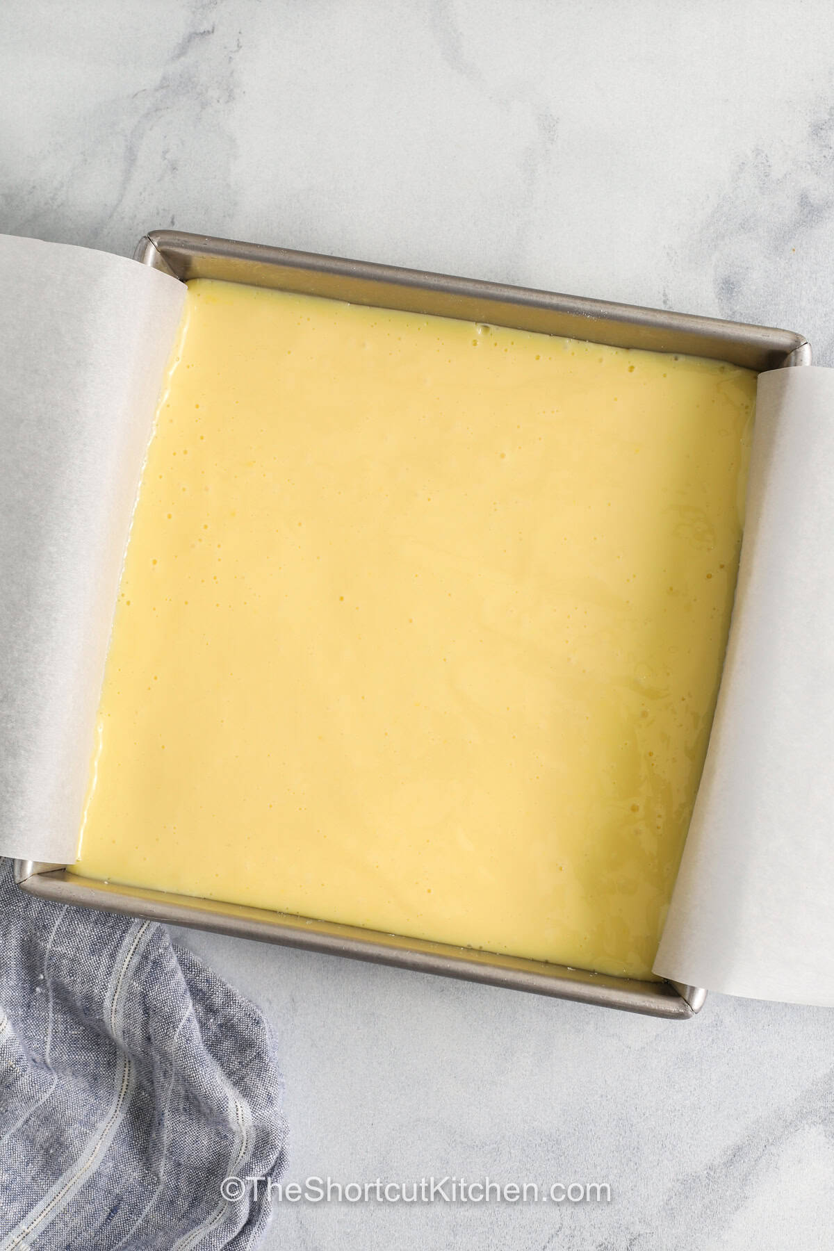 Easy lemon bars are a simple baked treat made with pantry staples and fresh lemons. The sugar cookie crust holds a smooth lemon layer that sets nicely after chilling. These bars are great for spring parties, bake sales, or dessert tables when you want something easy, fresh, and pretty enough to serve a crowd. They also store well, so you can make them ahead with no stress. #theshortcutkitchen Easy Lemon Bars in the dish