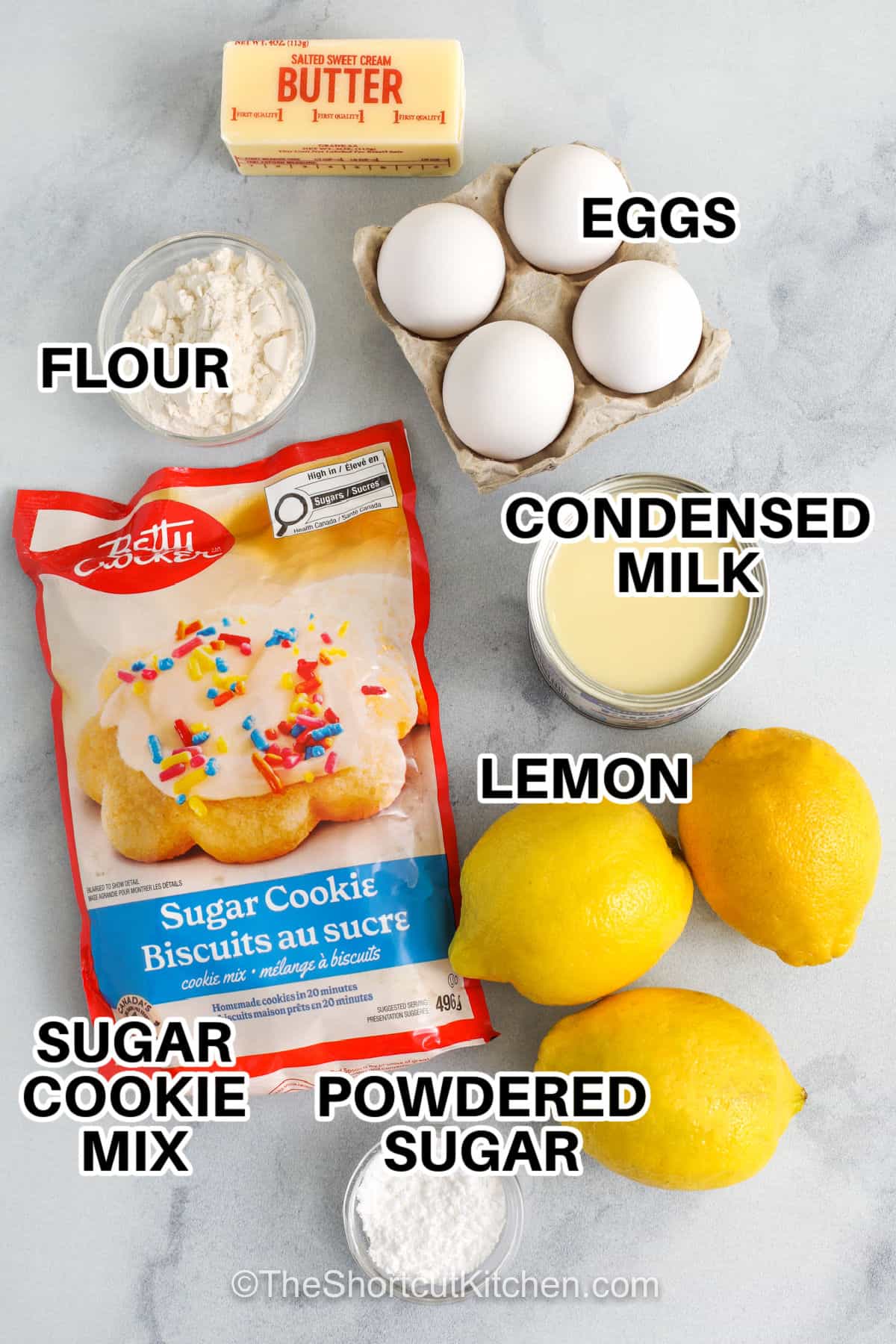 Easy lemon bars are perfect when you want a bright dessert without making a crust from scratch. Sugar cookie mix keeps prep quick, and the lemon filling with condensed milk and egg yolks bakes up smooth and creamy. These bars slice cleanly, travel well, and are great for make-ahead desserts for gatherings or family treats. A light dusting of sugar on top makes them look ready to serve. #theshortcutkitchen butter , eggs , flour , condensed milk , lemon , powdered sugar , sugar cookie mix on a counter with labels to make Easy Lemon Bars